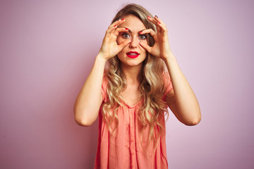 Young beautiful woman wearing t-shirt standing over pink isolated background Trying to open eyes with fingers, sleepy and tired for morning fatigue
