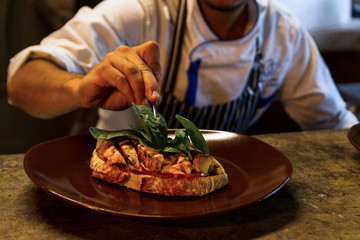 Chef garnishing a delicious tosta plate in a restaurant