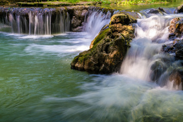 Fototapeta premium Waterfall in deep tropical rainforest with green tree