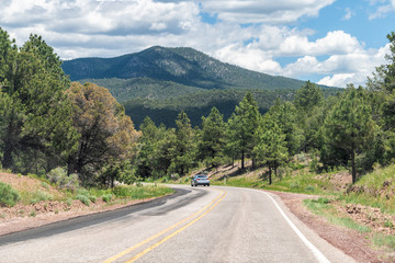 Fototapeta premium Carson National Forest highway 75 in Penasco, New Mexico with Sangre de Cristo mountains and green pine trees in summer at high road to Taos