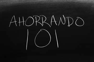 The words Ahorrando 101 on a blackboard in chalk.  Translation: Saving 101