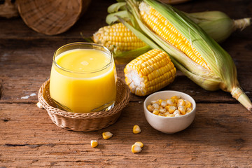 Fresh sweet corn juice (corn milk) and corn on wood background