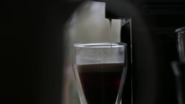 A cup of coffee filling up, ready to be enjoyed