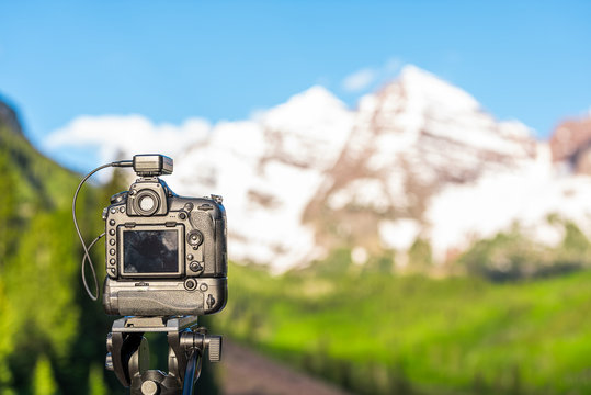 Maroon Bells at sunrise with dslr camera and tripod for time lapse photography in Aspen, Colorado with rocky mountain peak and snow