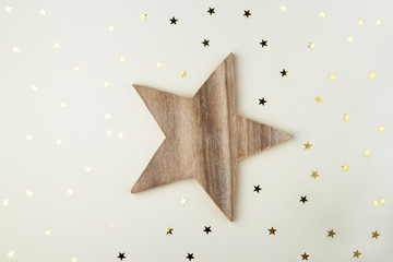 Wooden Star on white. Star shaped wooden object on white with little golden stars.