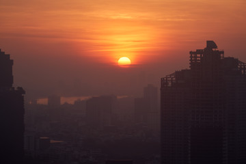 Fototapeta na wymiar sunrise burst circle on skyline and cityscape silhouette foreground