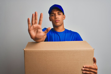 Young handsome arab delivery man holding a box standing over isolated white background with open...