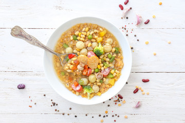 Tasty soup with legumes in bowl on white table