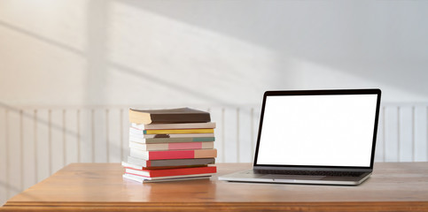 Open blank screen laptop with a pile of book - obrazy, fototapety, plakaty
