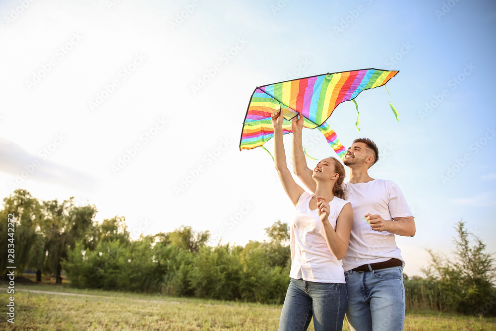 Canvas Prints Young couple flying kite outdoors