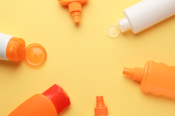Different sun protection creams on color background