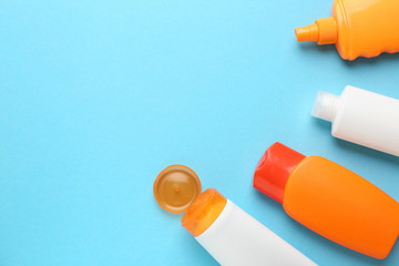 Different sun protection creams on color background