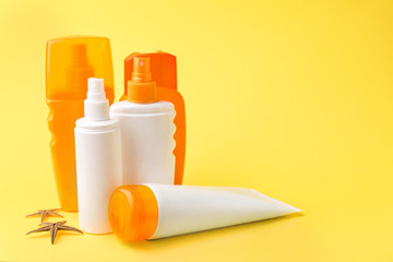 Different sun protection creams on color background