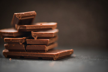 chocolate bar stacked on the dark background / close up Chocolate pieces and chunks candy sweet dessert and snack