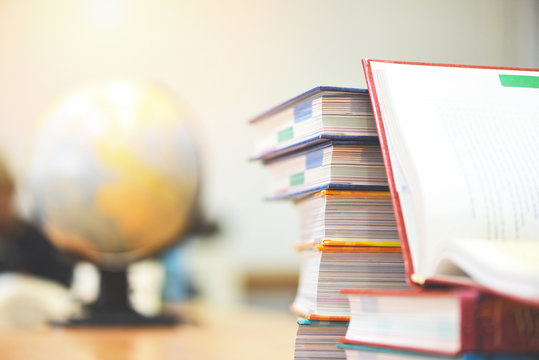 Education concept back to school and business study global world - open book in library with book stacked and earth globe model map
