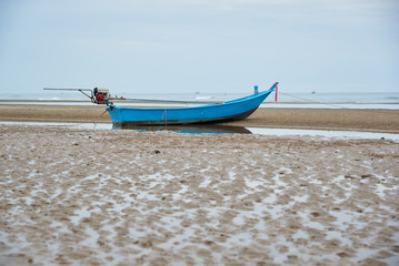 A blue fisherman boat on the beach