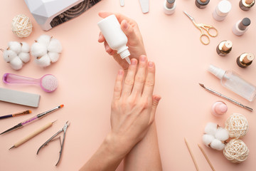Obraz na płótnie Canvas Nail care. beautiful women hands making nails painted with pink gentle nail polish on a pink background. Women's hands near a set of professional manicure tools. Beauty care