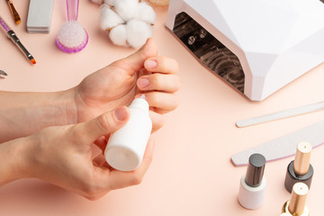 The concept of nail art. Woman gives herself a manicure on a white table, wow behind the nails, close-up. care for the nails