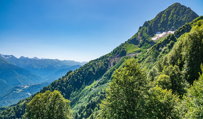 High mountains with green slopes and snowy peaks.