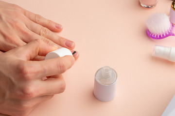 The concept of nail art. Woman gives herself a manicure on a white table, wow behind the nails, close-up. care for the nails