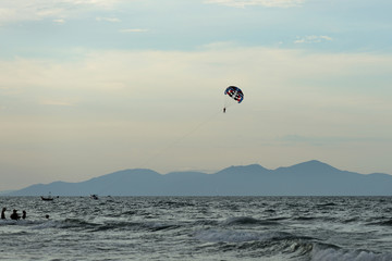 Parasailing on the background of the evening sky. Water activities on the coast of Vietnam