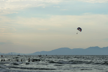 Parasailing on the background of the evening sky. Water activities on the coast of Vietnam