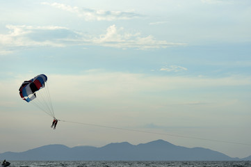 Parasailing on the background of the evening sky. Water activities on the coast of Vietnam