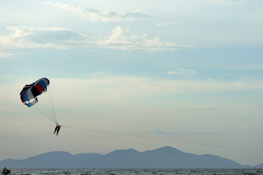 Parasailing on the background of the evening sky. Water activities on the coast of Vietnam