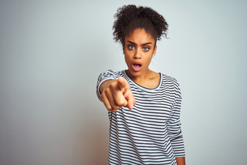 African american woman wearing navy striped t-shirt standing over isolated white background...