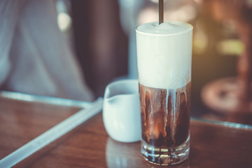 Black coffee or Americano on table with film vintage tone background.
