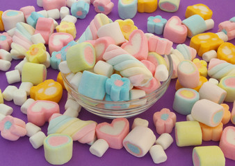 Colorful marshmallow candies in glass bowl and many marshmallow candies