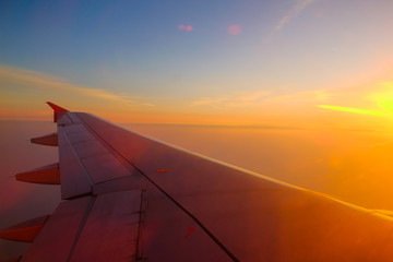 Naklejka na ściany i meble Flying and traveling, view from airplane window on the wing on sunset time