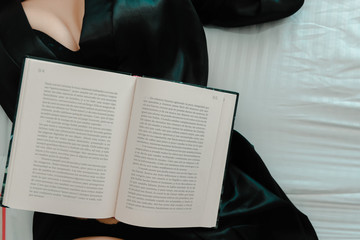 mujer acostada con libro encima en lencería y brasier 