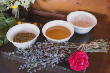 A beautiful girl with dark hair and a slender figure takes bath procedures in a Hammam, a bath attendant does massage, applies cosmetic oils and means to the skin of a slender young girl