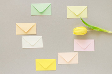 Colorful envelopes on grey paper background, copy space.
