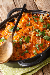 baked cabbage with ground beef, onions and cheese close-up in a pan. vertical