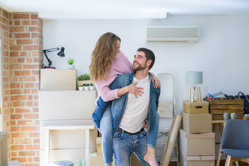 Young couple moving to a new house, boyfriend giving a piggy back ride to girlfriend, very happy and cheerful for new apartment