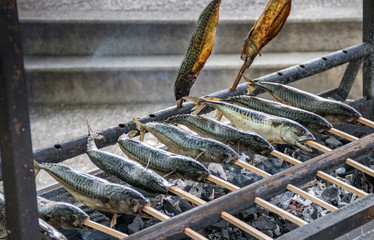 Steckerlfisch (Stangerlfisch, Staberlfisch) traditionell über Holzkohlegrill, Detail
