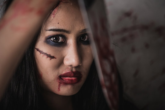 Horror Picture of a female killer at bloody knife honding hand with scary face, Depression and fear.