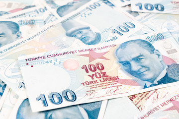 Fototapeta premium Istanbul, Turkey - 17 April, 2019: 100, One hundred banknote Turkish Lira Currency stacked up on white background for business, finance and exchange. Forex and Financial concept.