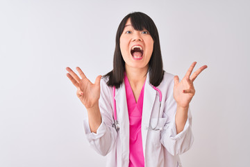 Young beautiful chinese doctor woman wearing stethoscope over isolated white background celebrating crazy and amazed for success with arms raised and open eyes screaming excited. Winner concept