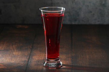 Red juicy drink in a high beer glass	