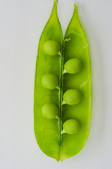 young pea pod with six peas inside