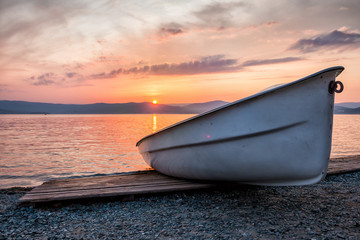 Boat on the lake against the backdrop of a picturesque sunset