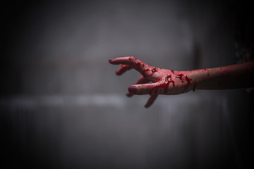 Nightmares of scary fear at the halloween festival. Close up bloody hands protruding from the wall,...