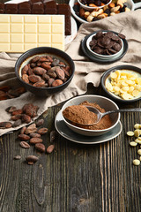Dark bitter, milk and white chocolate,  cocoa butter, cacao powder and beans on wooden table.