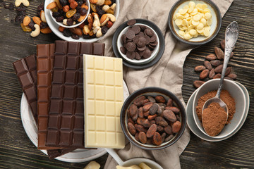 Dark bitter, milk and white chocolate,  cocoa butter, cacao powder and beans on wooden table.
