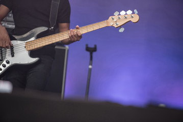 Fototapeta na wymiar Detail of a musician playing on a bass guitar