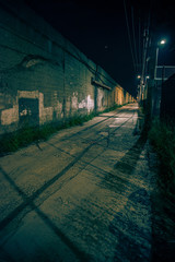 Fototapeta na wymiar Dark and eerie urban city alley at night 