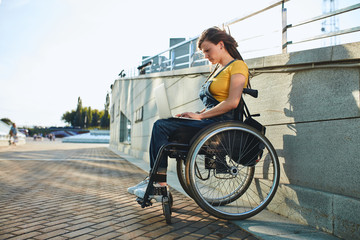 beautiful woman with physical challenges working from home, full length side view photo. girl sells goods, clothes, books online.